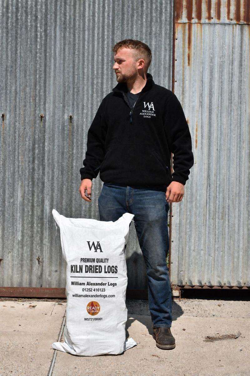 A member of the William Alexander team with a bag of kiln-dried logs