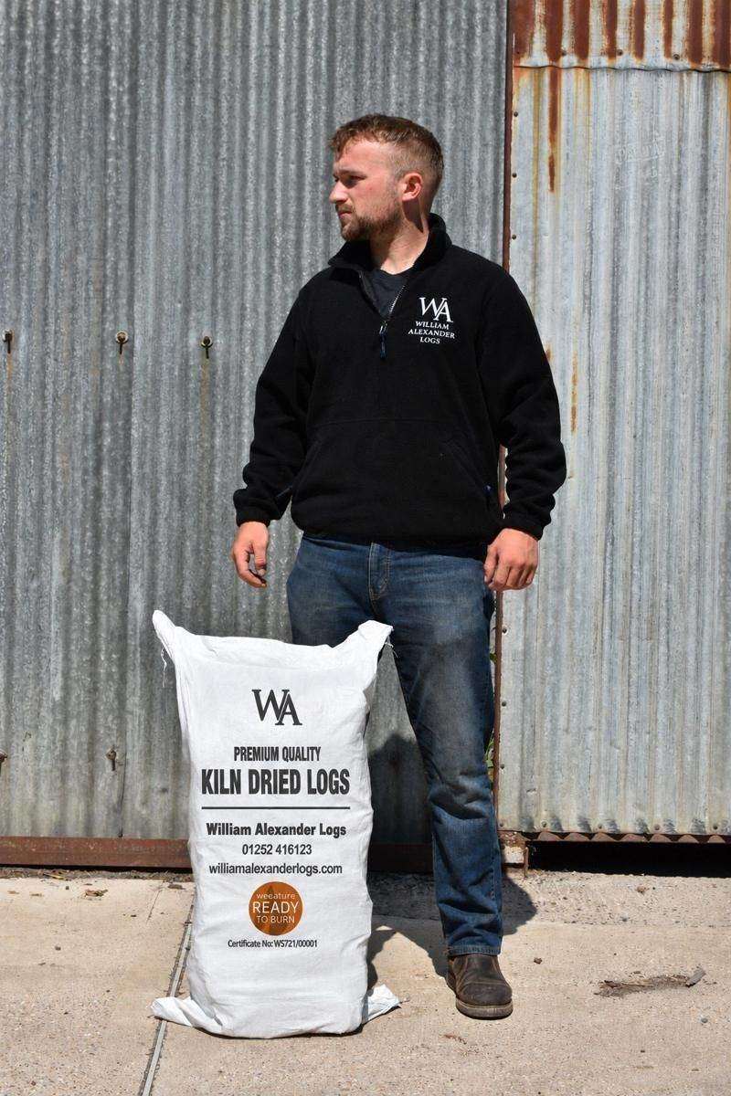 A member of the William Alexander team at the yard in Winchfield with a bag of kiln-dried logs